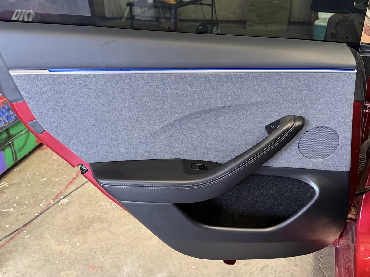 Deep-cleaned Tesla door panel with spotless fabric upholstery